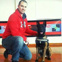 Policeman kneeling next to police dog